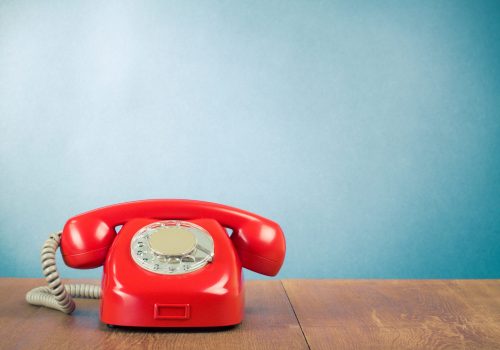 Retro,Red,Telephone,On,Wood,Table,Near,Aquamarine,Wall,Background